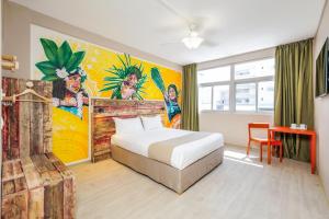 努美阿Gondwana City Art的卧室配有一张床,墙上挂有绘画作品