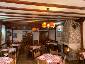 Vega del CadornoHotel Restaurante Rio Cuervo的一间带桌椅和壁炉的餐厅