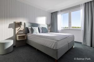 弗瓦迪斯瓦沃沃Belmar Park Resort & SPA的一间卧室设有一张床和一个大窗户