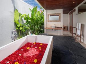 金巴兰Avery Le Nixsun Villas Uluwatu by Waringin Hospitality的浴室设有装满红色物品的浴缸。