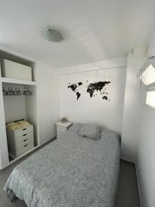 贝纳尔马德纳Apartamento Los Cisnes的卧室配有一张床,墙上有地图