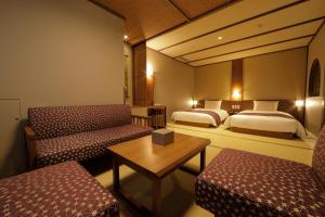 汤泽町Yukinohana的酒店客房,设有两张床、一张桌子和长凳