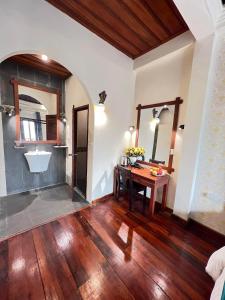 琅勃拉邦Chaluenxay Xiengthong Place的客房设有木桌和水槽。
