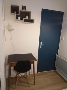 图卢兹Appartement cosy au centre-ville de Toulouse的一间设有书桌和蓝色门的房间