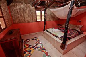 Jinack IslandJinack Lodge的一间设有床铺的卧室,位于一个红色墙壁的房间