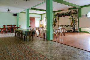 Colonia Parcela Number OneRedDoorz @ Star Jewel Lodge Apayao的一间拥有绿色墙壁和木桌及椅子的用餐室