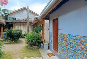 Colonia Parcela Number OneRedDoorz @ Star Jewel Lodge Apayao的一座有门的房子和一座种植植物的院子