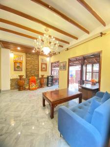琅勃拉邦Chaluenxay Xiengthong Place的客厅配有蓝色的沙发和桌子