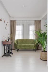 约阿尼纳Petrou Suites的客厅配有一张绿色沙发,设有一张桌子