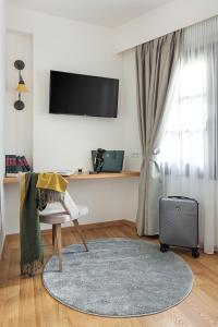 约阿尼纳Petrou Suites的一间带电视和手提箱的客厅