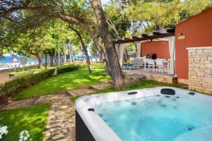 乌马格Istrian Villas Plava Laguna的房屋的院子内的热水浴池