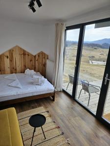 锡尔内亚Ursa Mica Glamping Resort的一间卧室设有一张床和一个美景阳台