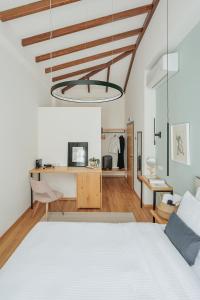 约阿尼纳Petrou Suites的卧室配有白色的床和书桌