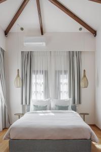 约阿尼纳Petrou Suites的一间卧室设有一张大床和两个窗户。