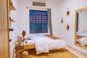 基加利Cozy Stays Kigali的一间卧室配有一张床和镜子