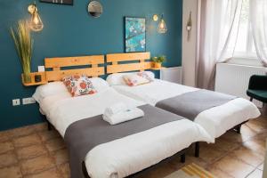 Fraisse-sur-AgoutLogis hôtel Auberge de l'Espinouse的蓝色墙壁客房的两张床