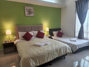 哥打巴鲁The Viana Apartment 2的一间卧室配有两张带红白色枕头的床