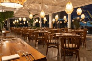卡斯特沃托诺Plana Resort & SPA的餐厅设有木桌、椅子和吊灯。