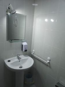 蓬费拉达Hostal Conde de Lemos的白色的浴室设有水槽和镜子