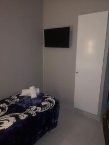 蓬费拉达Hostal Conde de Lemos的卧室配有一张床,墙上配有电视
