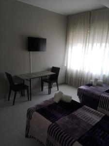 蓬费拉达Hostal Conde de Lemos的客房设有两张床、一张桌子和一张桌子以及椅子。