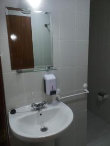 蓬费拉达Hostal Conde de Lemos的浴室设有白色水槽和镜子