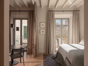 索列尔Can Verí Suites的一间卧室配有一张床铺和一张桌子,并设有一个阳台