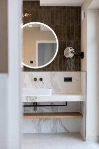 韦斯特兰DAS LORNSEN - Serviced Luxury Apartments的一间带镜子和水槽的浴室