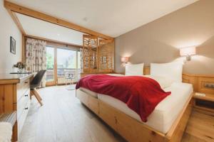 施伦斯阿尔奔蒙塔丰酒店的一间卧室配有一张大床,上面有红毯