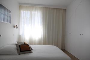 圣纳泽尔La petite chaumine的白色的卧室设有床和窗户