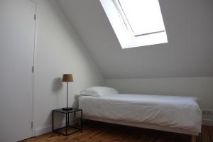 圣纳泽尔La petite chaumine的白色的卧室设有床和窗户