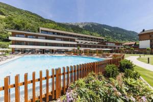 施伦斯阿尔奔蒙塔丰酒店的一座带大型游泳池的度假村,位于一座建筑前