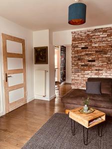 阿德瑙[E] ifeel home_ Adenau的带沙发和砖墙的客厅