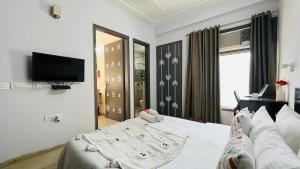 古尔冈BluO 1BHK Medanta Medicity, Kitchen, Balcony, Lift的卧室配有白色的床和电视。