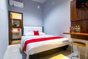 雅加达RedDoorz near Kebon Jeruk Jakarta的一间卧室配有一张红色枕头的床