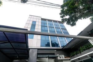 雅加达RedDoorz near Kebon Jeruk Jakarta的一面是一座带玻璃窗的建筑