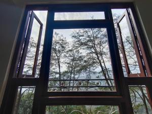 甘托克Shanol Residency的透过窗户可欣赏到树木的景色