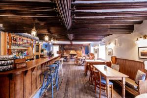 BlythburghWhite Hart Inn的一间带桌椅的餐厅和一间酒吧