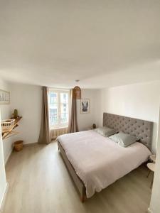 格朗维尔Appartement Les Corsaires的一间卧室设有一张大床和一个窗户。