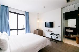 曼谷Uno Express (SHA)的卧室设有白色的床和大窗户