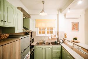 扎金索斯镇Melos House的厨房配有绿色橱柜和水槽