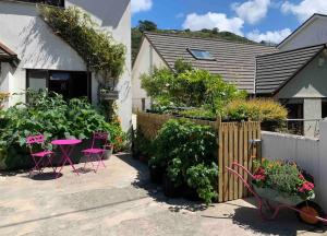 波斯陶恩Brook beach retreat, Porthtowan, Cornwall的花园设有桌椅和植物