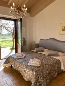 皮蒂利亚诺Villa Vacasio Bio-Eco的一间卧室配有一张大床和一个吊灯。