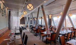 斯德哥尔摩斯堪塔克酒店的餐厅设有桌椅和大窗户。