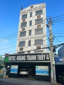 胡志明市Khách Sạn Hoàng Thanh Thủy 4的前面有标志的酒店大楼