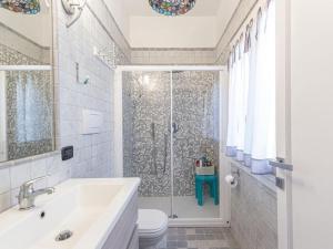阿罗纳Villa Monastero的带淋浴、卫生间和盥洗盆的浴室