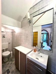 阿罗纳Villa Monastero的一间带水槽、卫生间和镜子的浴室