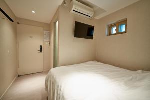 首尔Life in Euljiro的卧室配有白色的床和电视