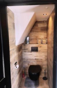 OudenboschHet Blij Hoen的浴室设有黑色卫生间和木墙