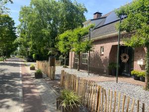 OudenboschHet Blij Hoen的街道旁的砖屋,有木栅栏